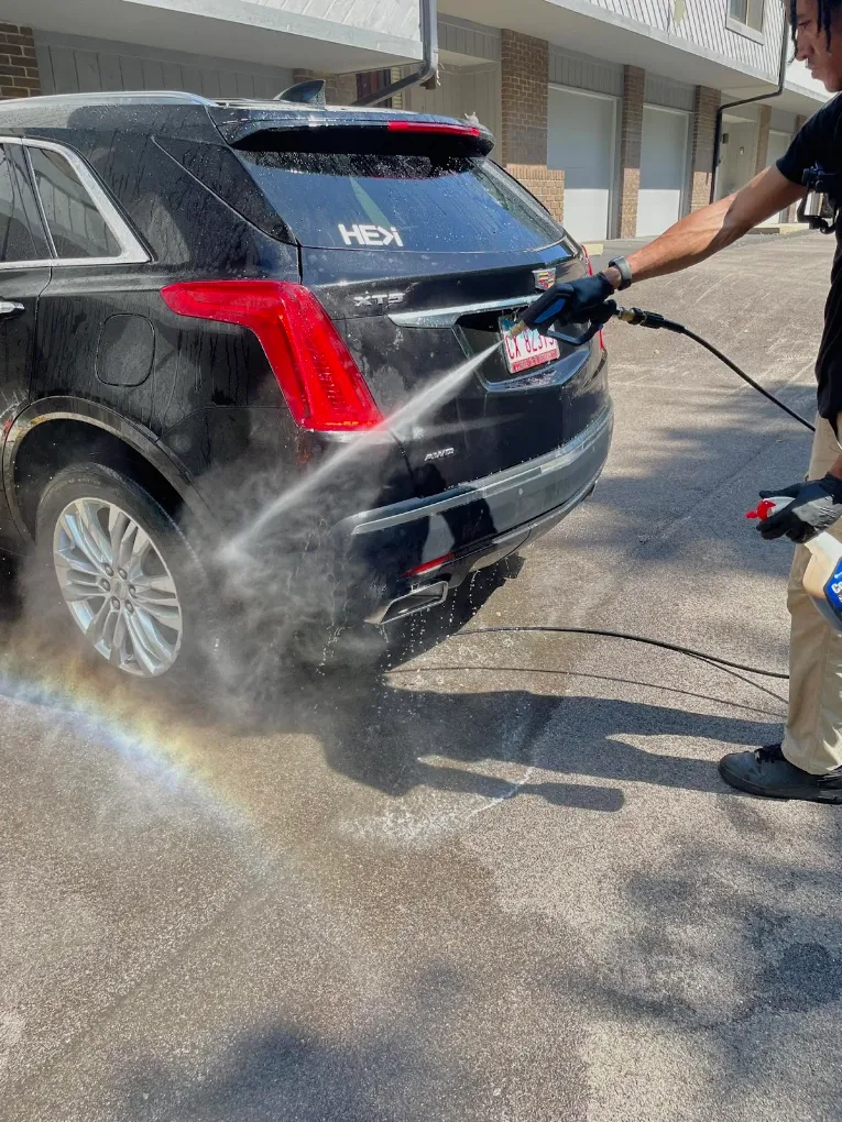 Rinsing a black Cadillac XT5 after exterior mobile detailing in Danville IL